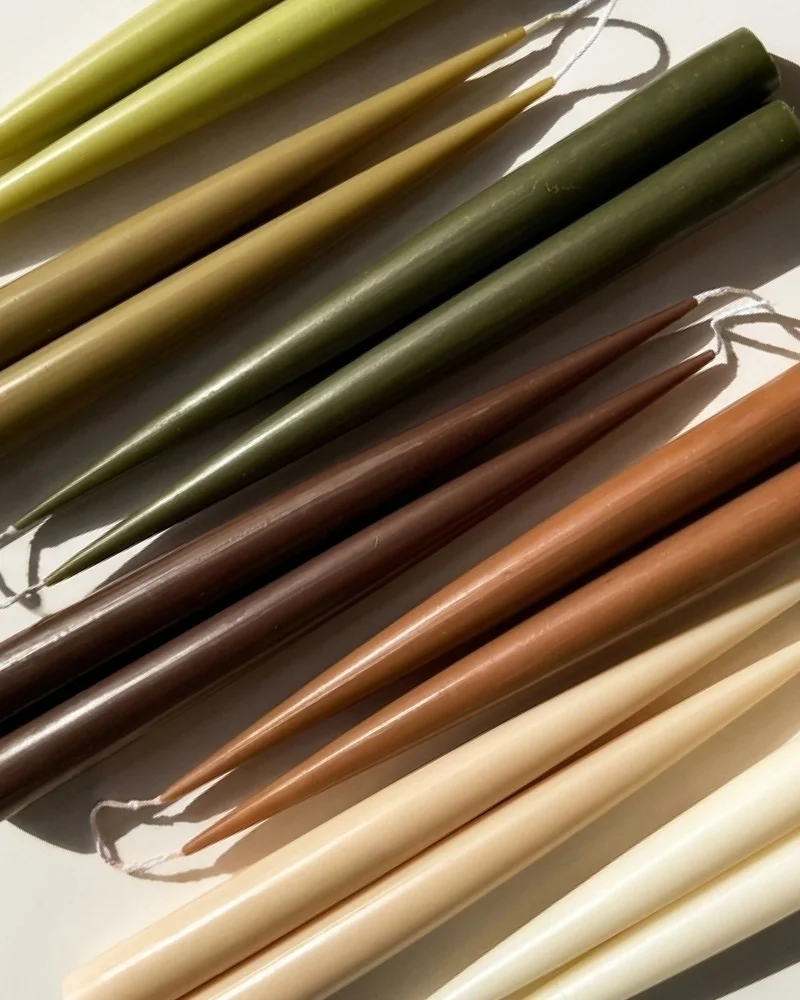 Sculptural candles standing upright with a smooth, column-like form.