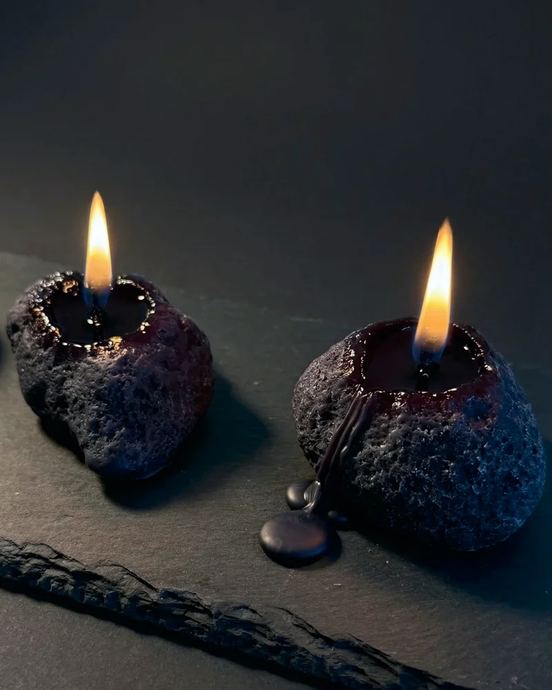 Sculptural candles standing upright with a smooth, columnar form.