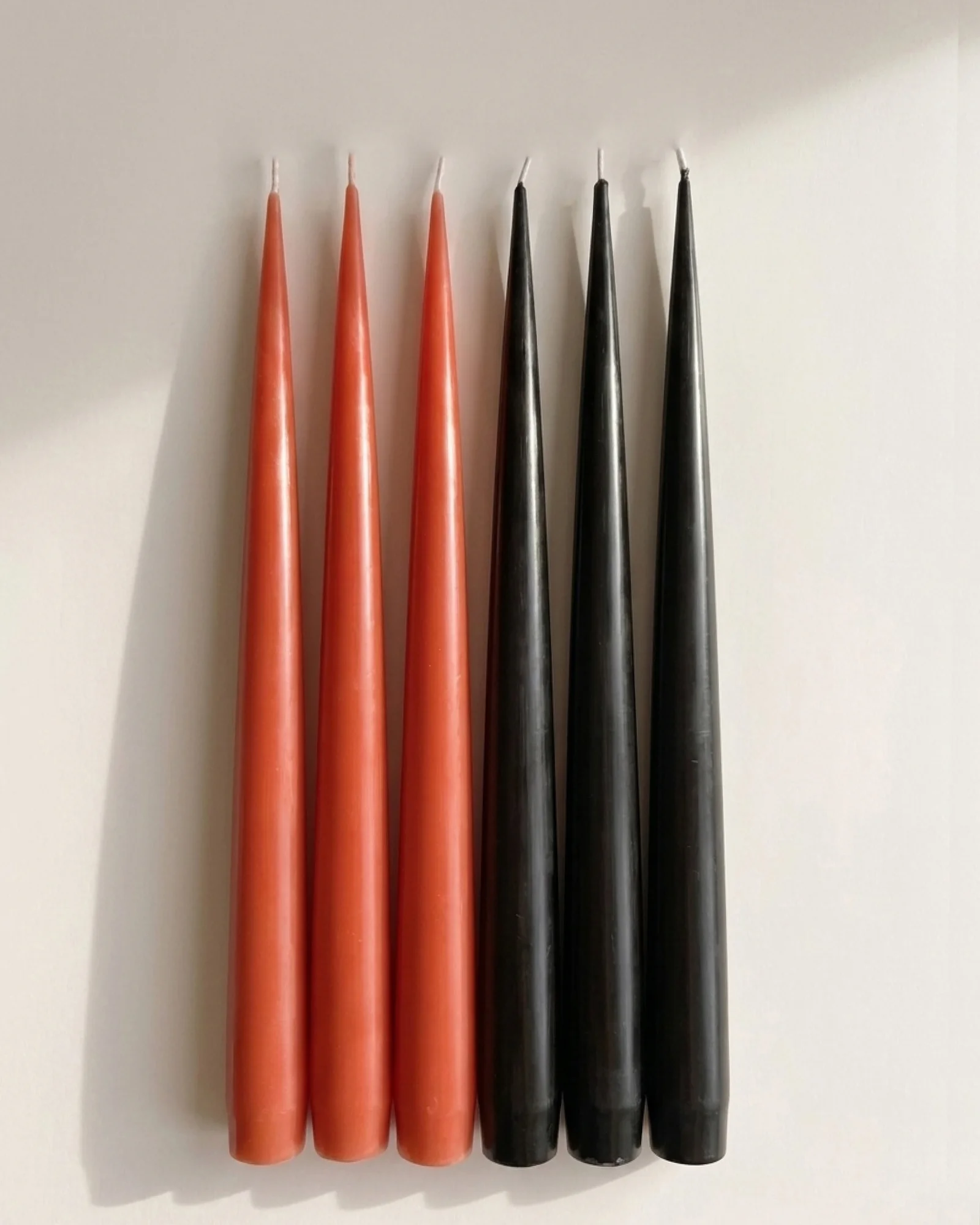Sculptural candles standing upright with a smooth, column-like form.