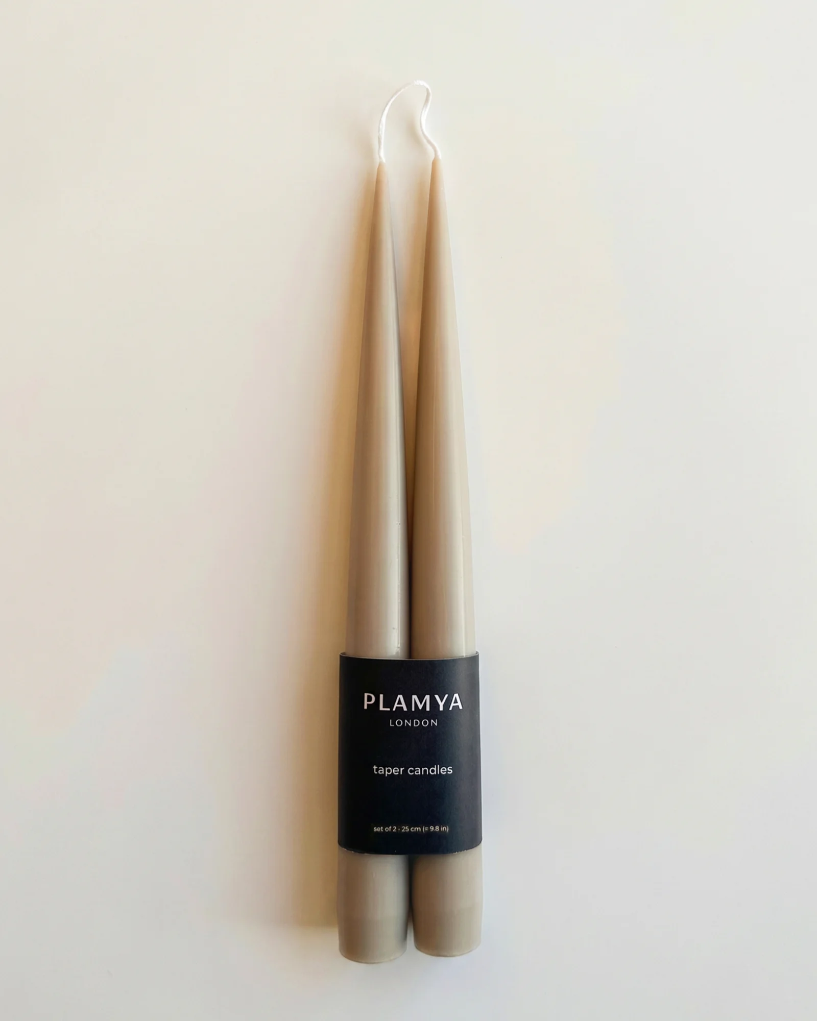 Sculptural candles standing upright with a smooth, minimal form.
