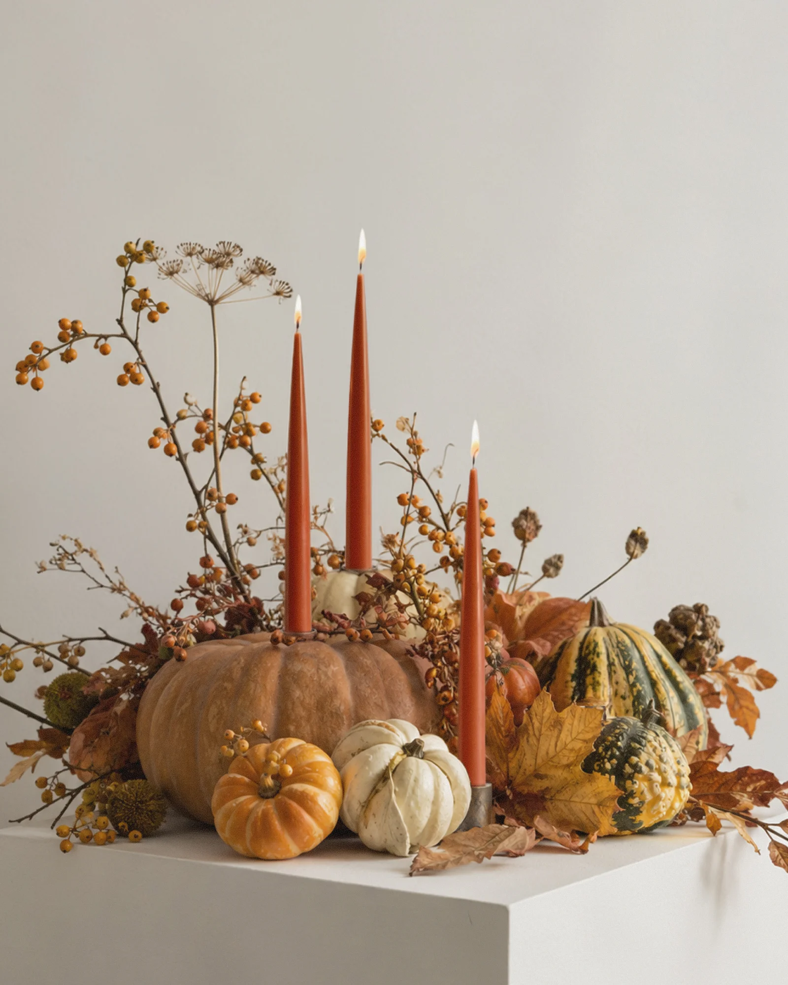 Sculptural candles standing upright with a smooth, matte surface.