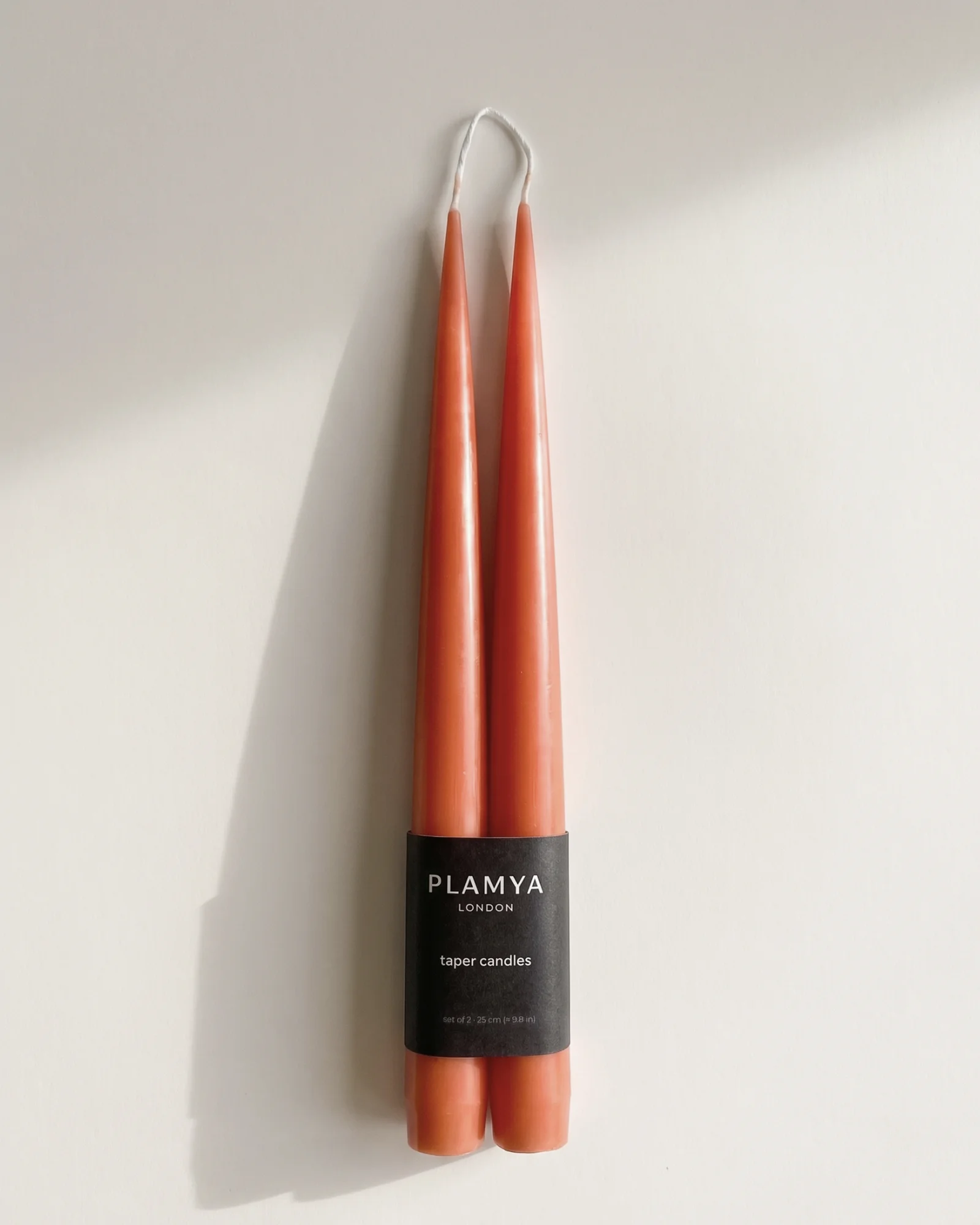 Sculptural candles standing upright with a smooth, matte surface.
