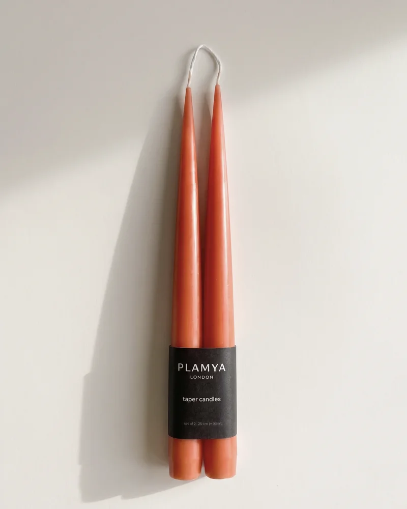 Sculptural candles standing upright with a smooth, matte surface.