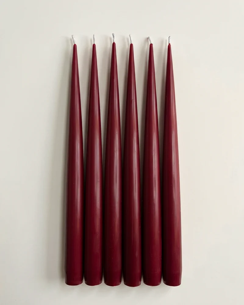 Six Vivid Red taper candles arranged side by side