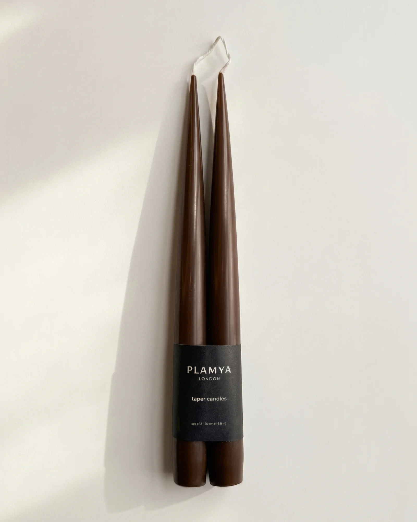 Pair of earth brown PLAMYA taper candles wrapped with a black paper band