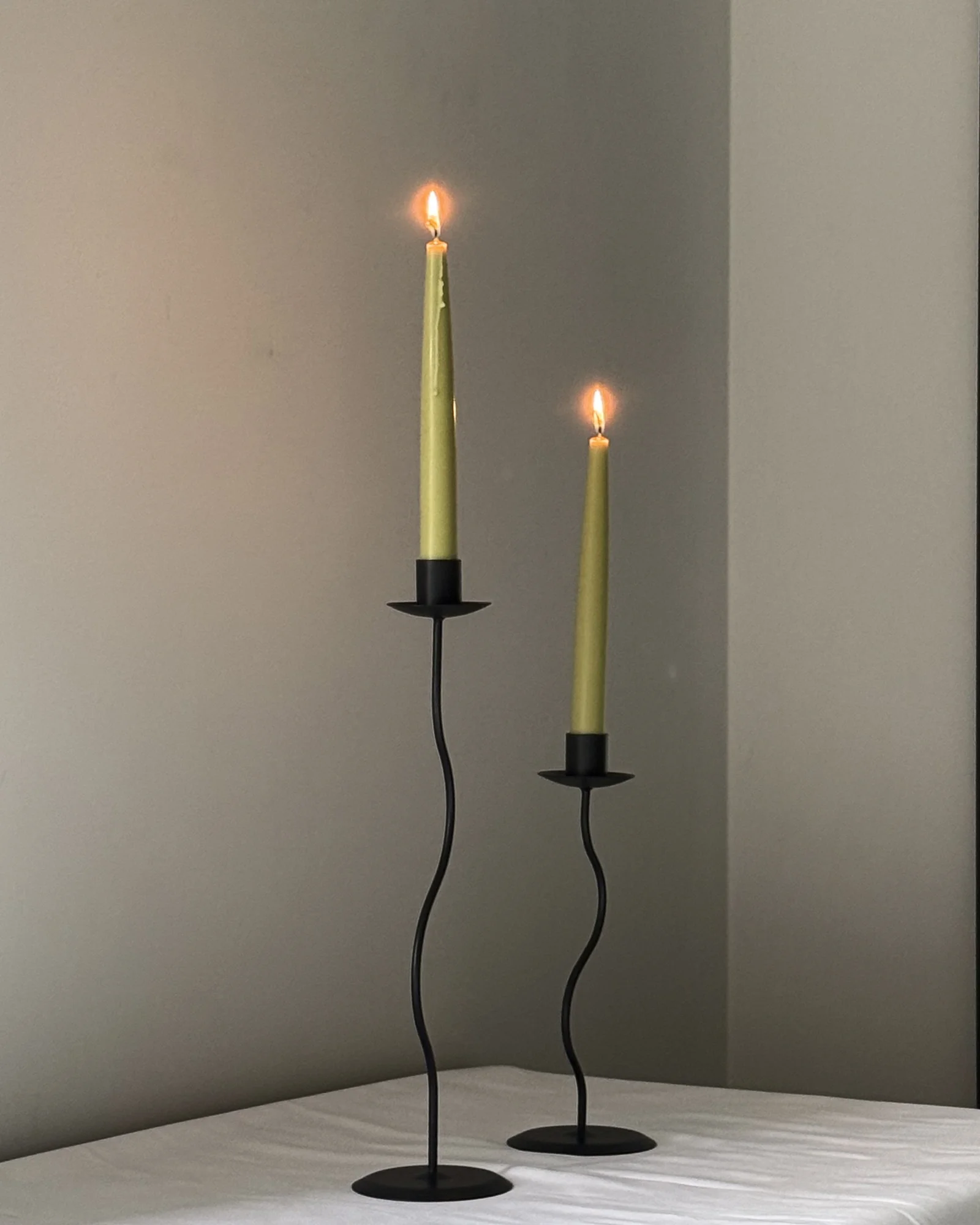 Sculptural candles standing upright with a smooth, minimal form.