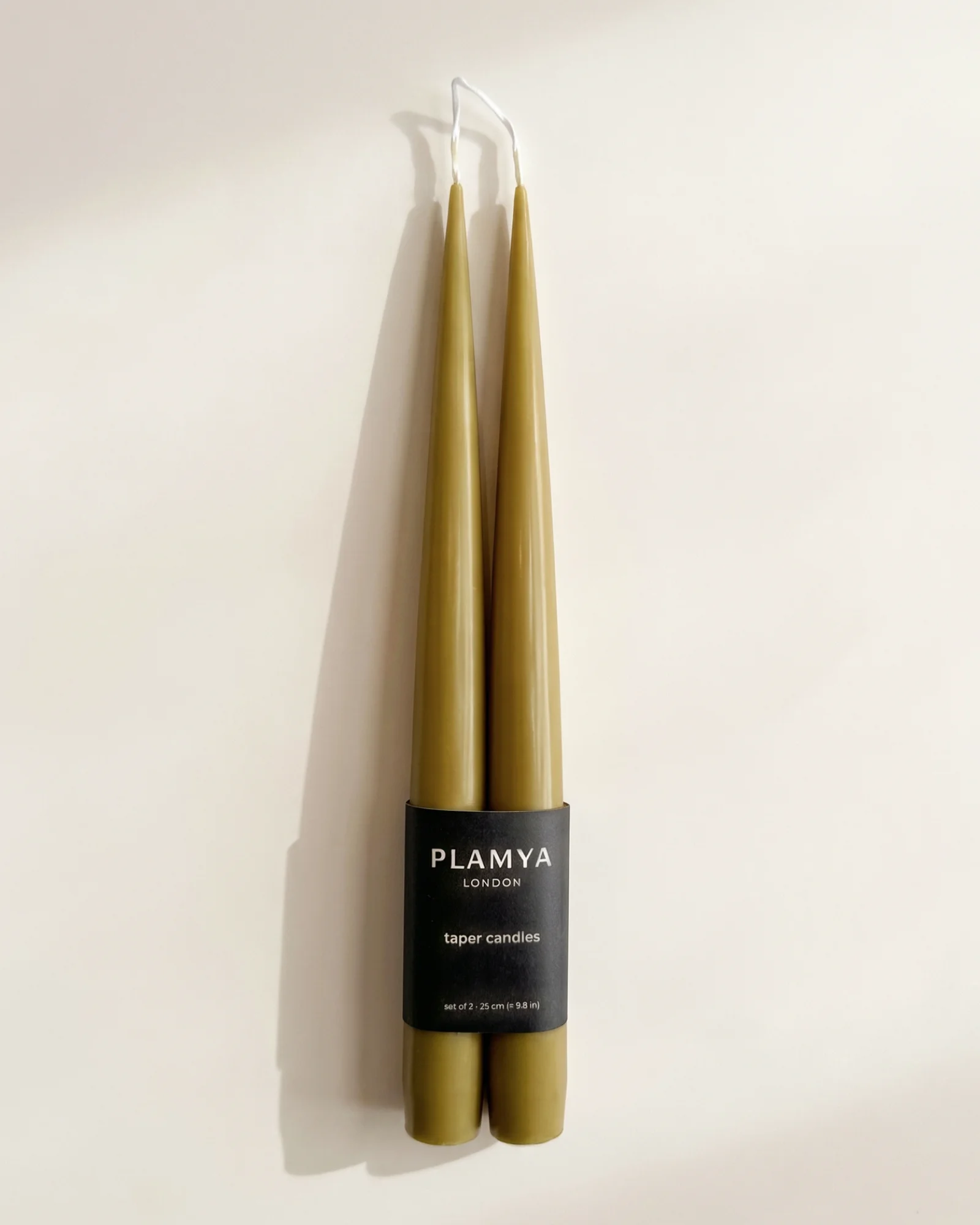 Olive taper candle pair wrapped with a black PLAMYA paper band