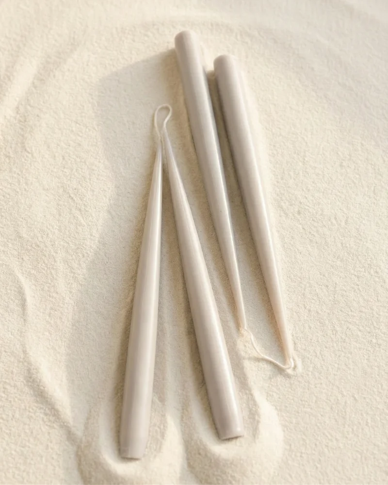 Sculptural candles standing upright with a smooth, minimal form.