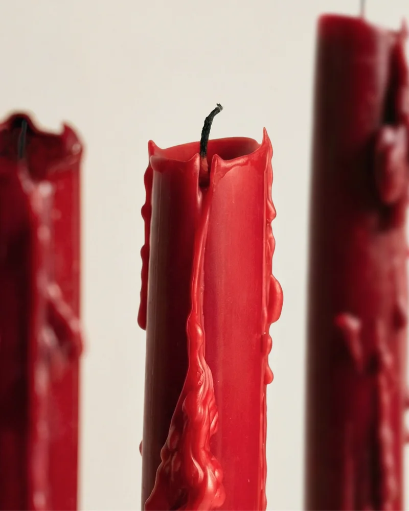 Sculptural candles standing upright with a smooth, minimalist form.