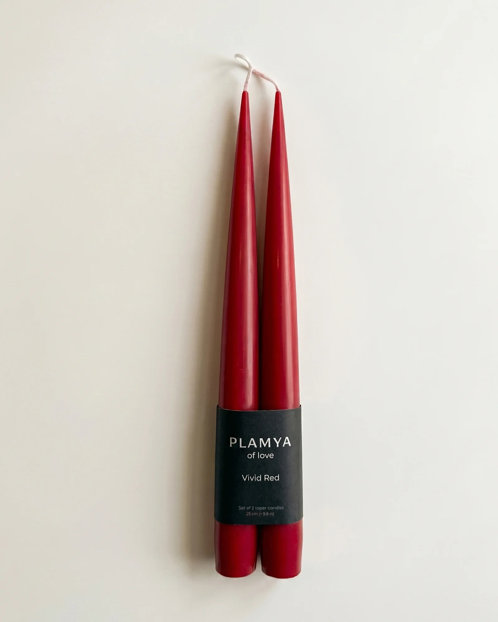 Vivid Red taper candle pair wrapped with a black PLAMYA paper band