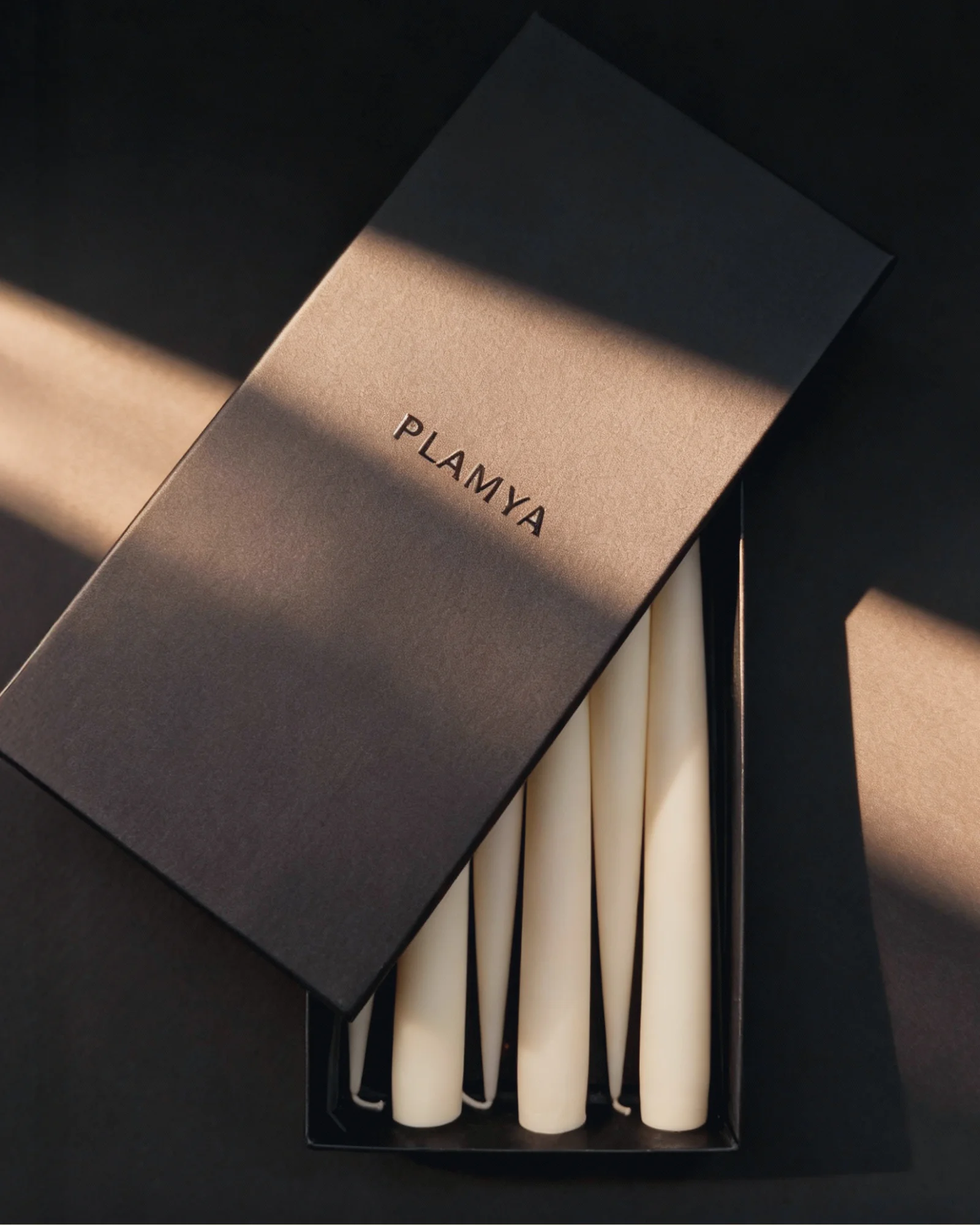 Sculptural candles standing upright, their forms creating a minimal composition.