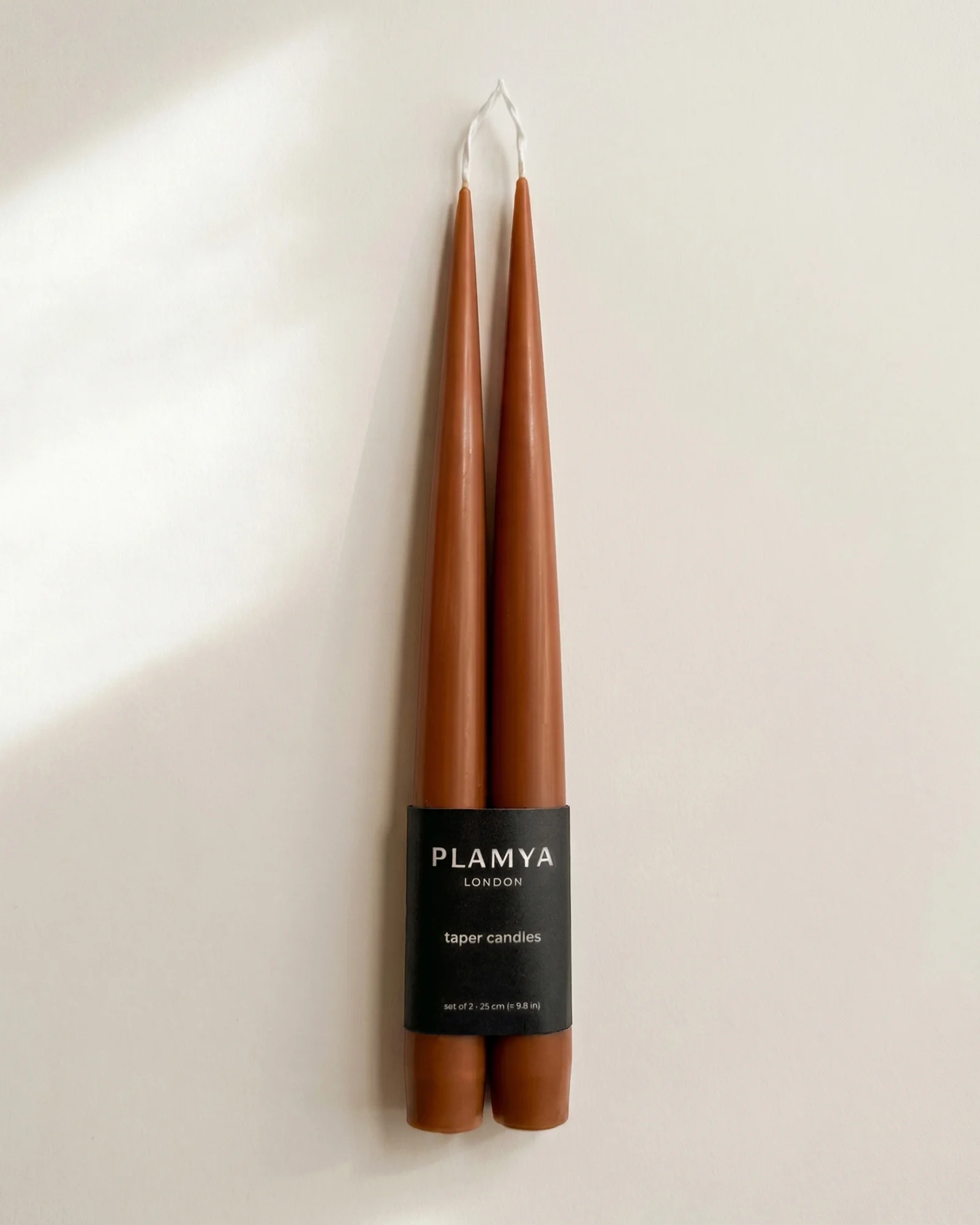 Warm Clay taper candle pair wrapped with a black PLAMYA paper band