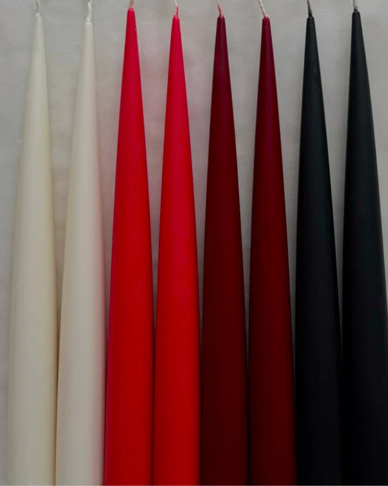 Sculptural candles standing upright with a smooth, minimal form.