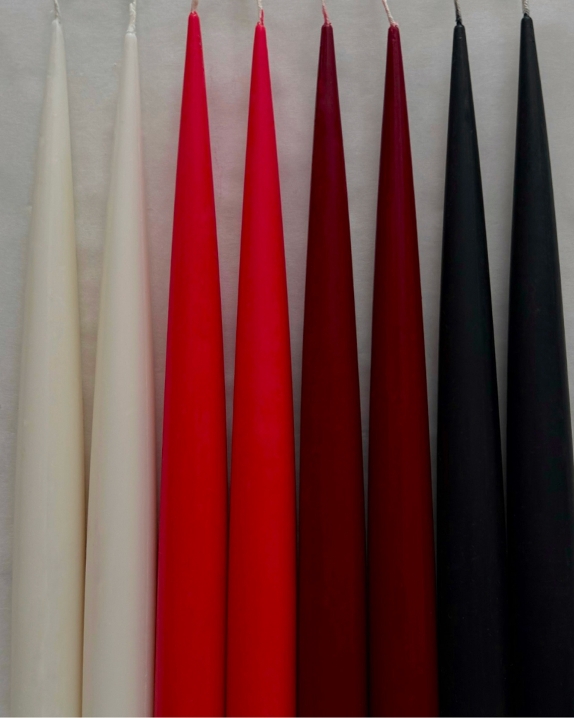 Sculptural candles standing upright with a smooth, minimal form.
